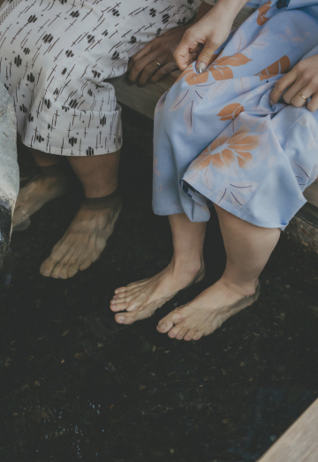 写真：足湯につかる浴衣姿の男女