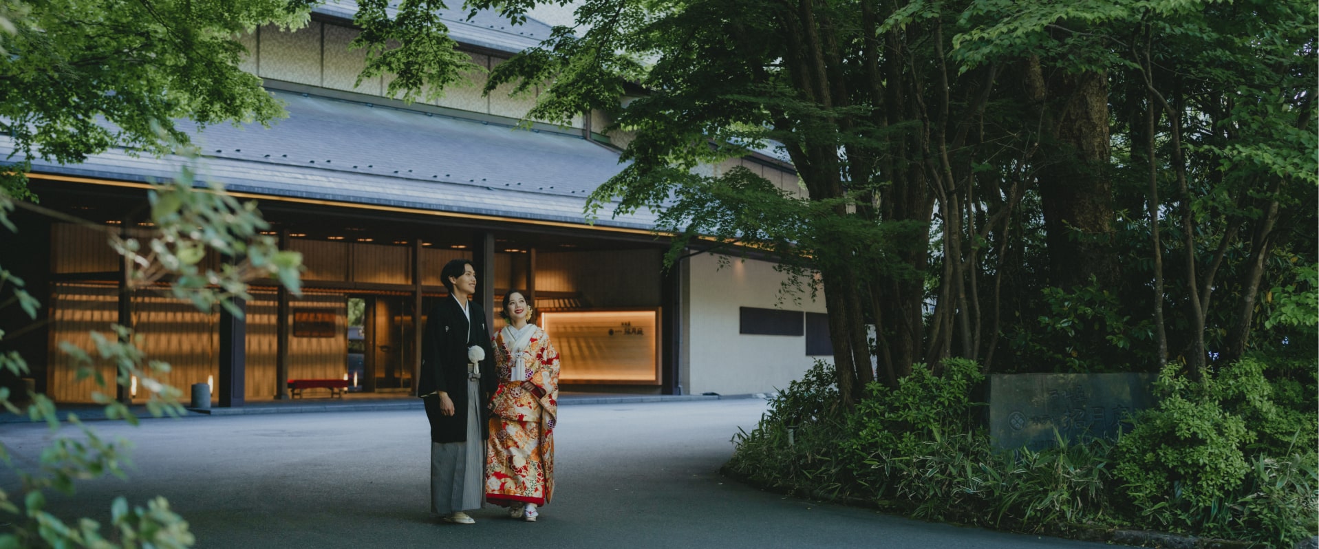 写真：西村屋ホテル招月庭の前を歩く、和装の婚礼衣装を着た新郎新婦