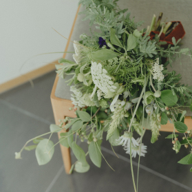 写真：椅子の上に置かれた白と緑の花束